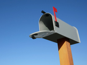 An open residential mailbox with flag up
